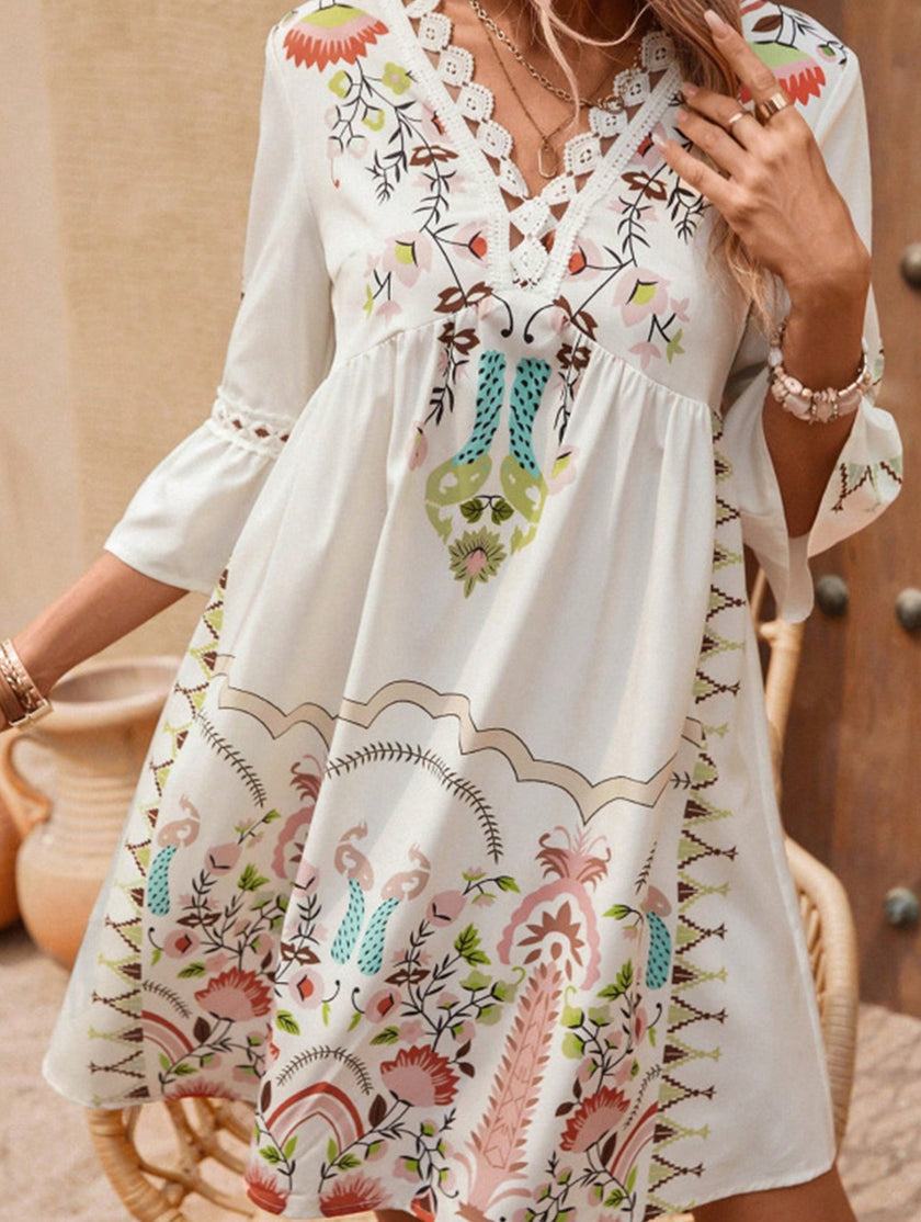 White V neck lace patch print dress by FJØRNA, featuring a flowy silhouette and intricate lace details.