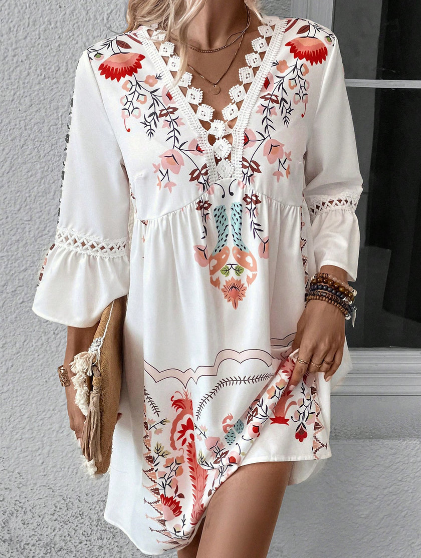 White V-neck lace patch print dress by FJØRNA, featuring intricate lace details and a stylish V-neck design.