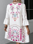 White V-neck lace patch print dress by FJØRNA, showing intricate lace details and a flowing silhouette.