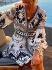 FJØRNA Printed Beach Mini Dress in black with colorful floral pattern, lightweight fabric, sleeveless design, perfect for summer outings.