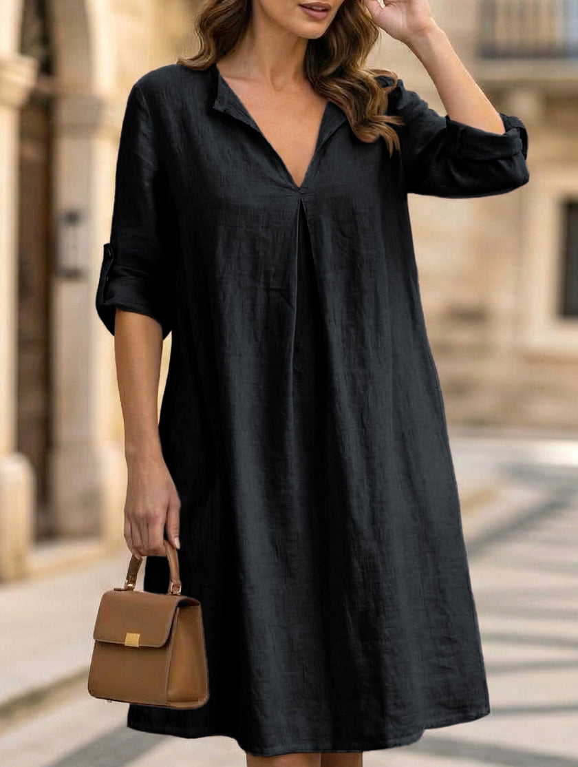Black linen V-neck short sleeve dress by FJØRNA, displayed on a hanger with a relaxed fit and simple design.
