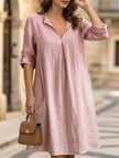 White linen V-neck short sleeve dress by FJØRNA, shown on a hanger with a relaxed fit and lightweight fabric.