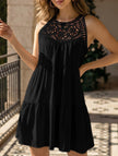 Black lace patch halter A-line dress by FJØRNA, featuring a fitted bodice and flowing skirt, displayed on a hanger.