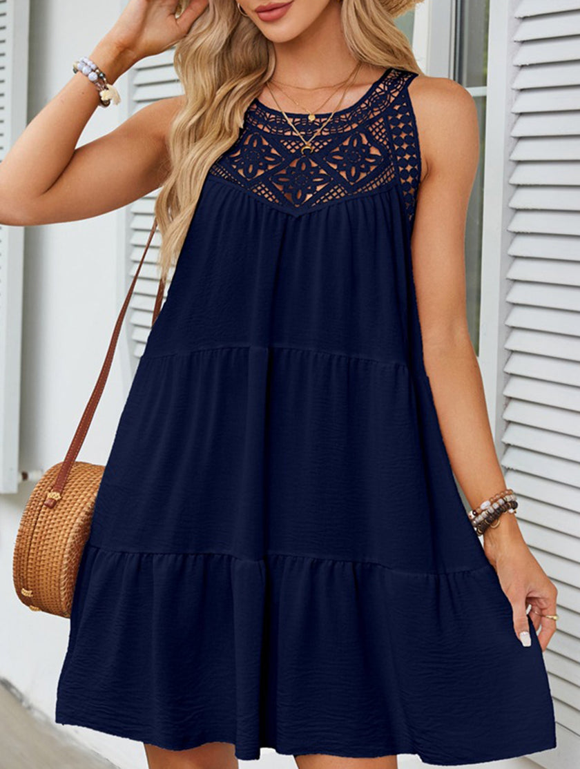 Navy lace patch halter A-line dress by FJØRNA, featuring a fitted bodice and flowing skirt, displayed on a hanger.