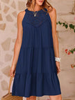 Navy lace patch halter A-line dress by FJØRNA displayed on a hanger, showcasing its elegant lace details and classic silhouette.