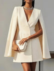FJØRNA white double-breasted cape blazer dress displayed on a hanger, featuring elegant design and structured silhouette.