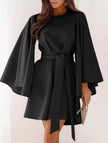 Black round neck flare sleeve belted dress by FJØRNA, featuring a stylish silhouette and elegant design.