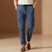 Blue men's cargo trousers by FJØRNA with drawstring waist, relaxed fit, and multiple pockets, ideal for casual wear.