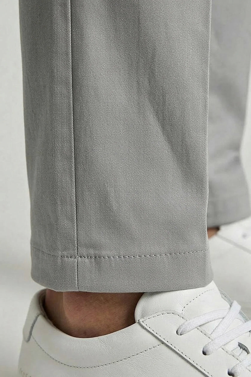 Men's FJØRNA straight chino trousers, smart structured business pants with tailored fit, shown in a stylish executive setting.