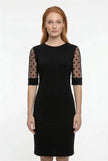 Black FJØRNA midi dress for women featuring an A-line silhouette with lace sleeves and contrasting fabric details.