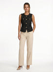 FJØRNA women's tailored sleeveless waistcoat with structured design, layered over a blouse, shown with minimalist pointed-toe heels.