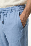 Light blue men's linen trousers by FJØRNA, breathable straight-fit summer pants with lightweight, comfortable fabric.