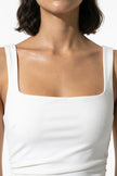 White high-slit maxi dress for women by FJØRNA featuring a sleeveless design and sling style, shown in a close-up macro shot.