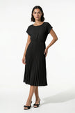 Black FJØRNA women's pleated midi dress with an A-line silhouette and round neckline, full-body view showing casual style.