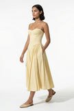 FJØRNA women's backless midi dress in butter yellow with sleeveless, pleated halter design, full-body view.