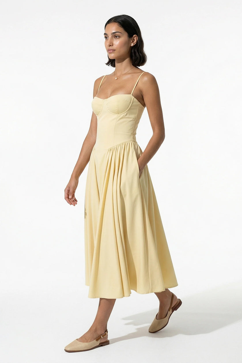 FJØRNA women's backless midi dress in butter yellow with sleeveless, pleated halter design, full-body view.