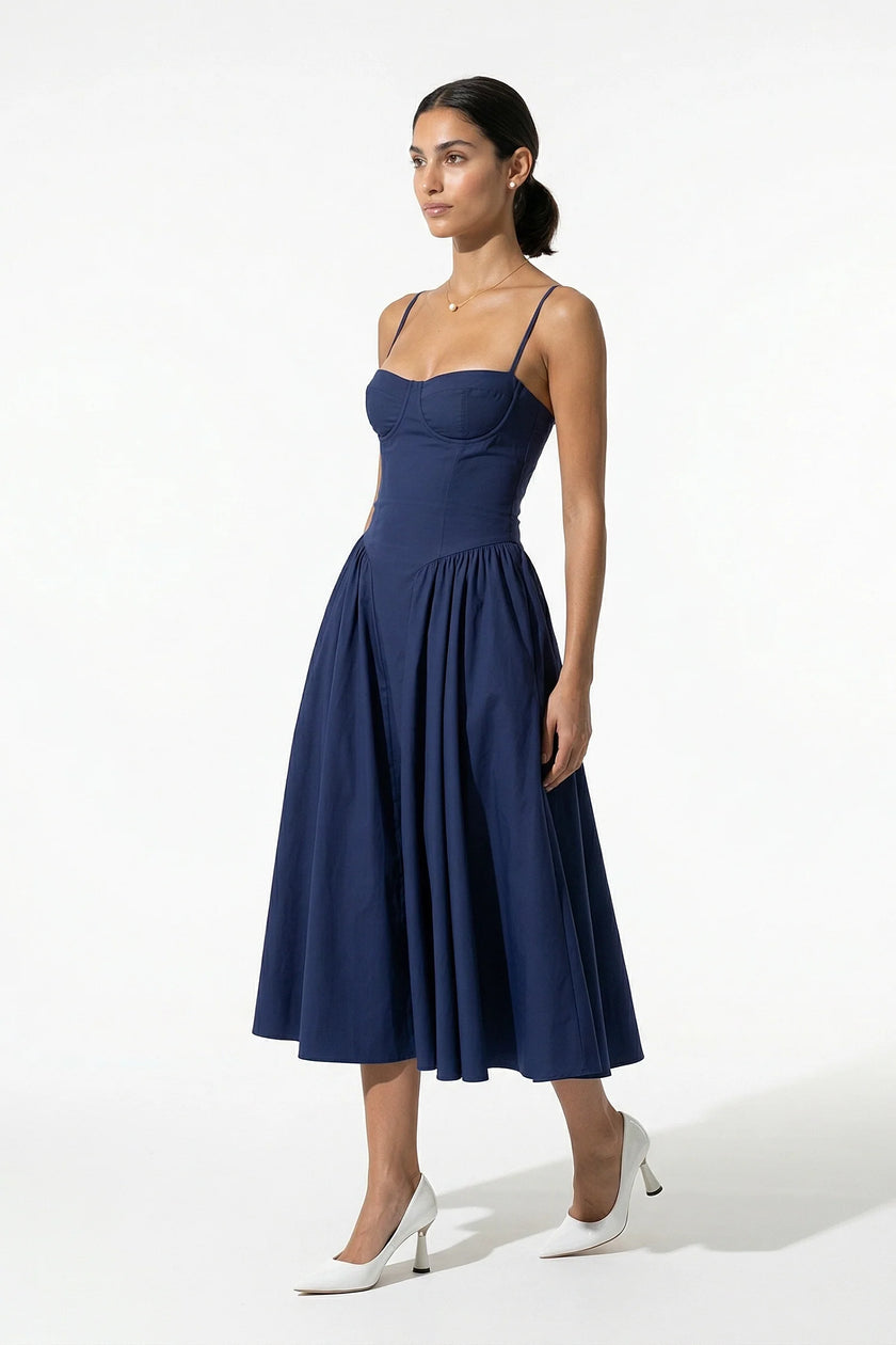 Deep blue FJØRNA backless sleeveless midi dress with pleats, halter neckline, and flowing skirt, full body view.