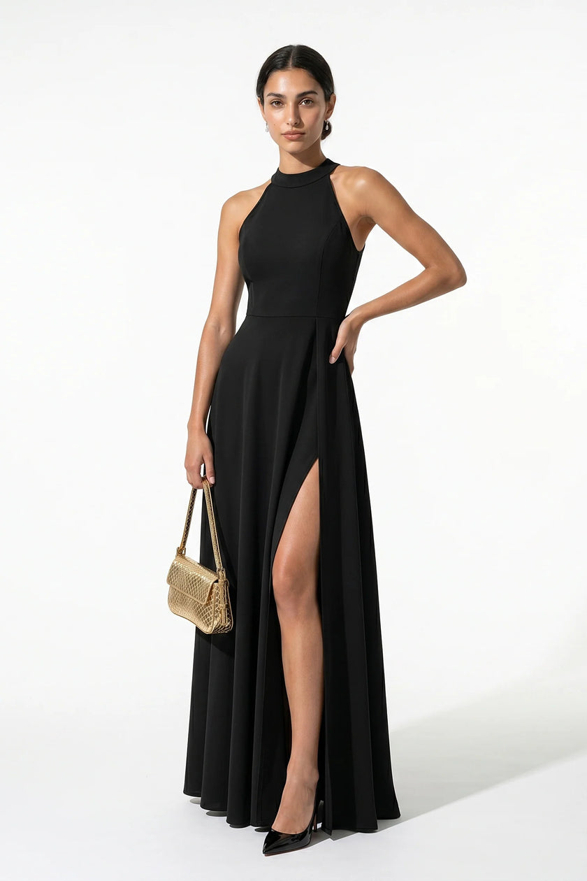 Black FJØRNA sleeveless maxi dress with high neck, A-line silhouette, and side slit, shown full-body on a woman.