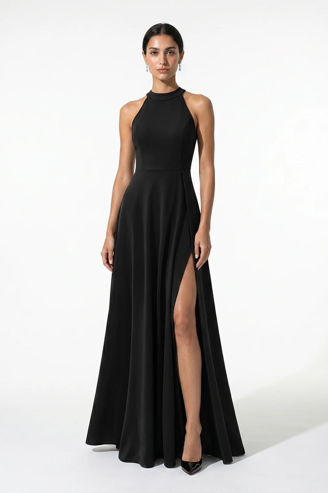 Black FJØRNA sleeveless maxi dress with high neck and side slit, featuring an A-line silhouette and elegant sleeveless design.