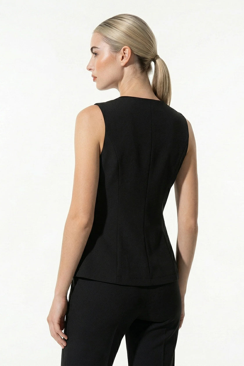 Black women's sleeveless waistcoat with tailored fit and metal button details from FJØRNA, shown in close-up detail shot.