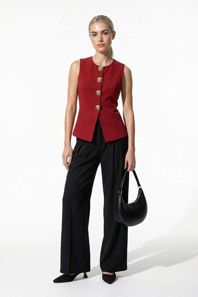 Women's deep red sleeveless waistcoat by FJØRNA with tailored fit and metal button details, shown from the front on a model.