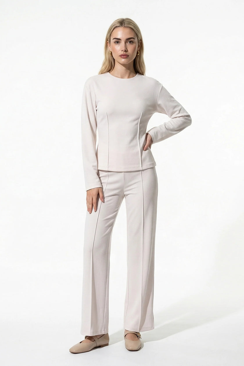 White women's slim fit co-ord set by FJØRNA featuring long sleeve top and wide-leg trousers, full-body view.