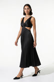 Black FJØRNA women's pleated maxi dress with V-neck, suspender straps, and hollow waist detail, full-body view.
