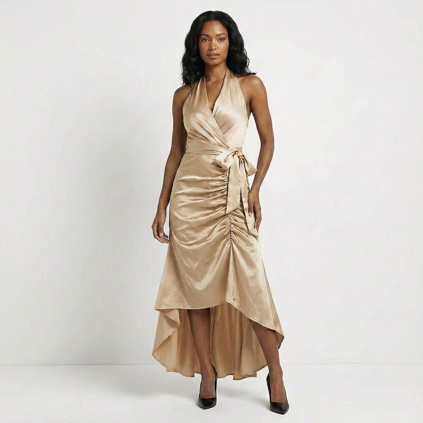 FJØRNA satin halter neck wrap maxi dress in champagne with ruffled hem and bow tie waist, elegant evening wear.