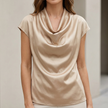 FJØRNA women’s champagne satin summer blouse with cowl neck and short sleeves, elegant and lightweight for warm weather.