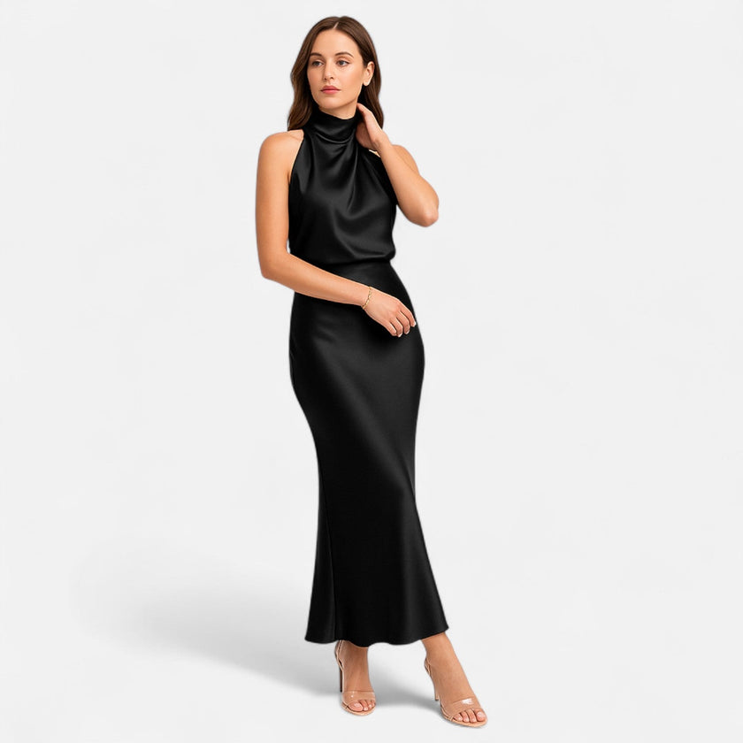 FJØRNA draped sleeveless halter maxi dress with flowing fabric, elegant style, and floor-length design in a soft, neutral color.