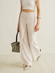 Lightweight women's summer trousers by FJØRNA featuring high waist and wide-leg wrap design on a model.