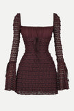 FJØRNA coffee-colored ruched mini dress displayed on a hanger, showcasing its fitted silhouette and textured fabric.