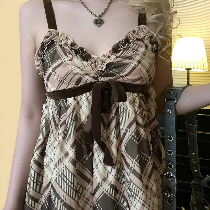 FJØRNA Coquette plaid mini dress displayed on a mannequin, featuring a fitted silhouette and classic plaid pattern.