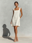 Cream linen sleeveless mini dress by FJØRNA featuring a simple, elegant design perfect for summer or evening wear.