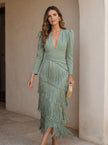 FJØRNA elegant women's v-neck fringe dress featuring a stylish design and flowing fabric, perfect for sophisticated occasions.