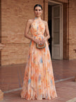Elegant FJØRNA women's maxi dress with a printed halter neck design, flowing fabric, and stylish silhouette.
