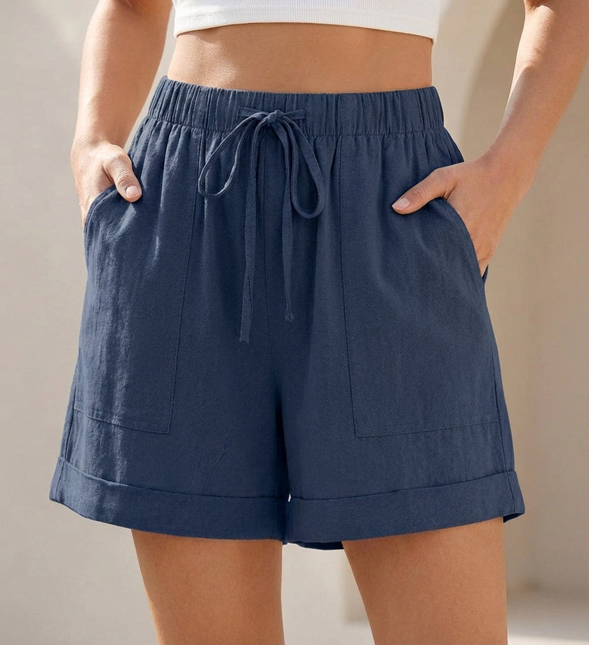 Dark blue women's summer shorts by FJØRNA with linen fabric, pockets, and drawstring waist for a casual, comfortable look.