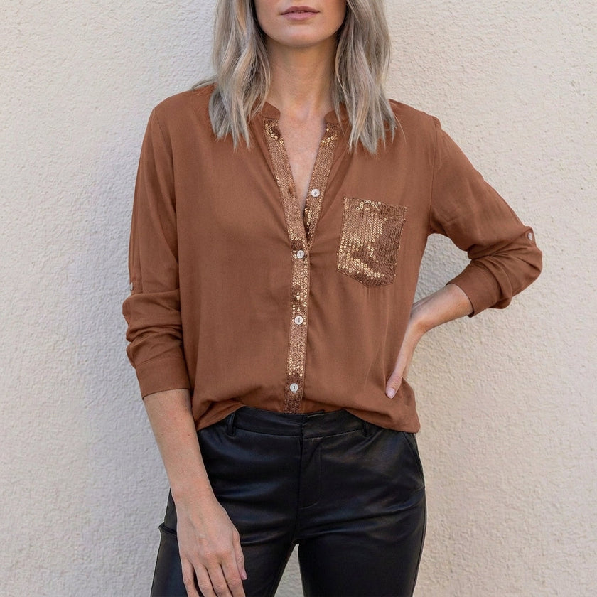 Dark brown women's summer blouse with V-neck, denim fabric, and button front from FJØRNA, shown on a model.