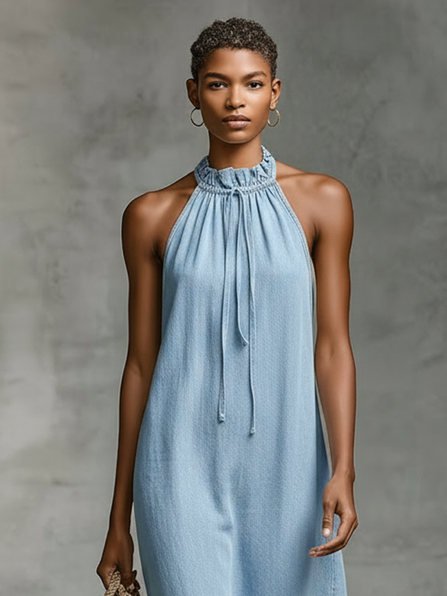 FJØRNA denim sleeveless midi dress for women featuring a fitted bodice and flowing skirt, styled with side pockets and adjustable straps.