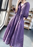 Purple FJØRNA cotton dress with lace patchwork, V-neck, lantern sleeves, and cinched waist, perfect for casual or wedding occasions.