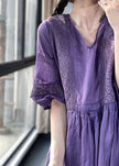 Purple FJØRNA cotton dress with lace patchwork, V-neck, lantern sleeves, and cinched waist, suitable for casual or wedding occasions.