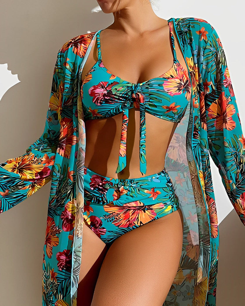 Women's floral bikini swimwear set with ruffles, three-piece design by FJØRNA featuring a colorful flower print and ruffled accents.