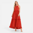 Lightweight, flowy women's tiered maxi dress with halter neck by FJØRNA, perfect for summer, shown in a natural outdoor setting.
