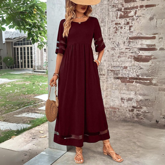 FJØRNA Elegant Maxi Dress in white, flowing fabric with a relaxed fit, perfect for casual or semi-formal occasions.