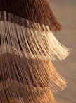 Close-up of FJØRNA elegant women's V-neck dress with fringe detail, showcasing the textured fabric and stylish neckline.