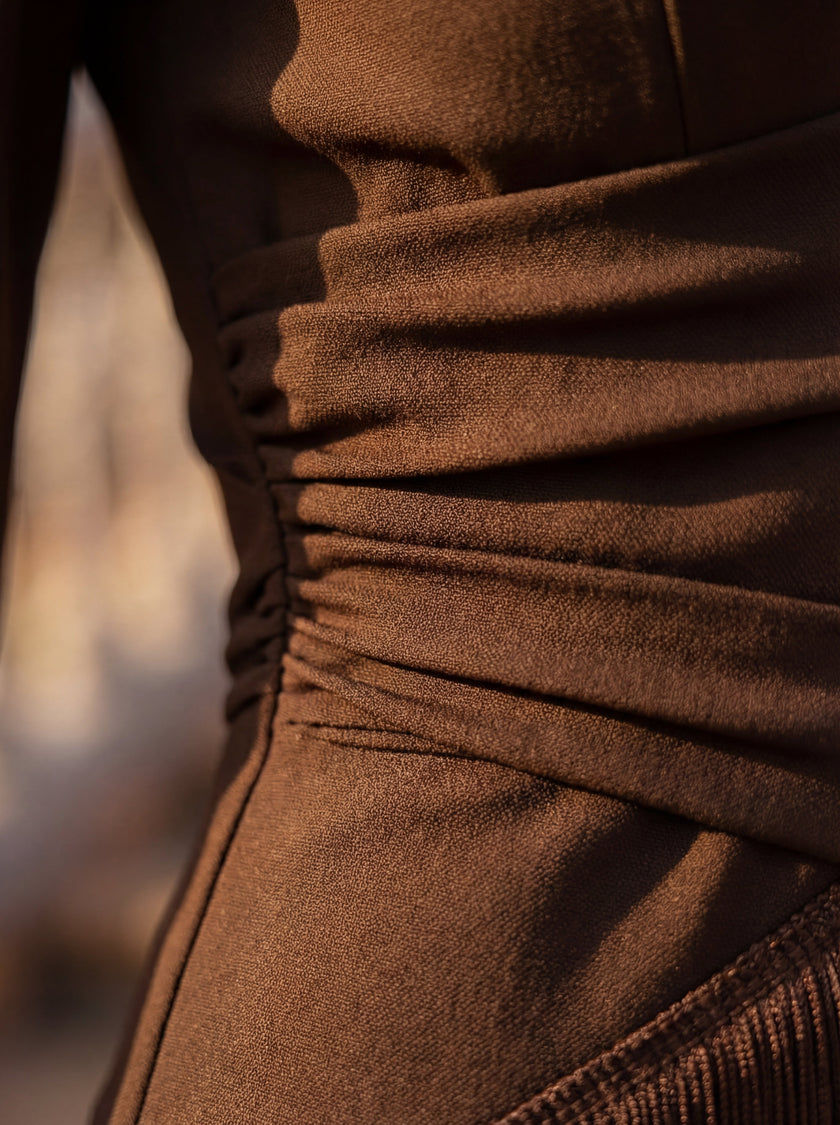 Close-up of FJØRNA women's elegant V-neck fringe dress showing intricate fringe details and fabric texture.