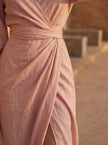 Close-up of FJØRNA women's elegant V-neck linen maxi dress showing textured fabric and detailed stitching.