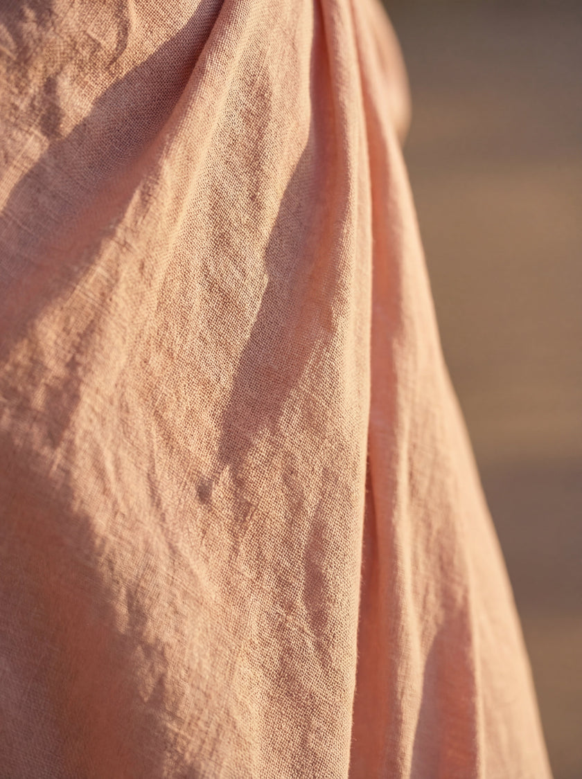 Close-up of FJØRNA women's elegant V-neck linen maxi dress showing textured fabric and detailed stitching.
