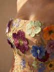Close-up of FJØRNA elegant floral strapless midi dress for women, showcasing delicate fabric and intricate floral details.