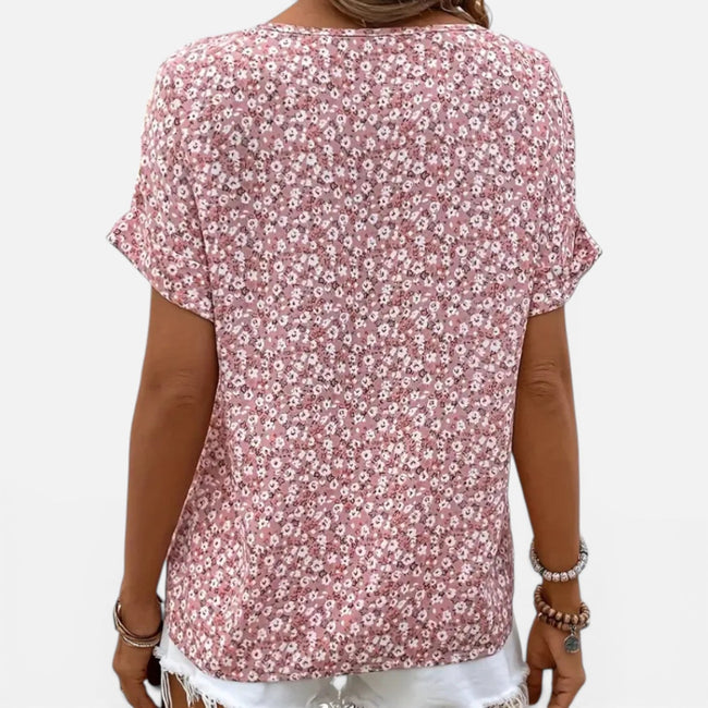 Women's floral cotton blouse by FJØRNA with button front, lightweight casual fit, featuring a colorful floral pattern.